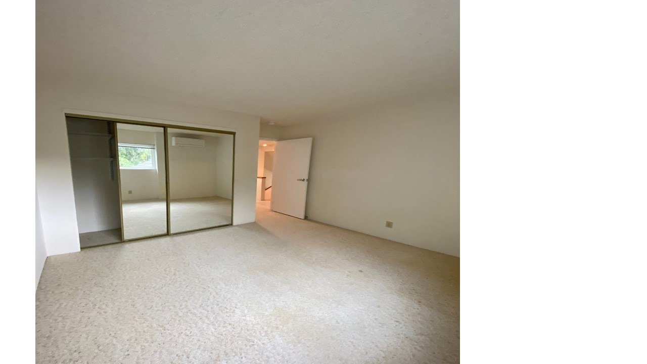 A room with a carpeted floor and a sliding glass door.
